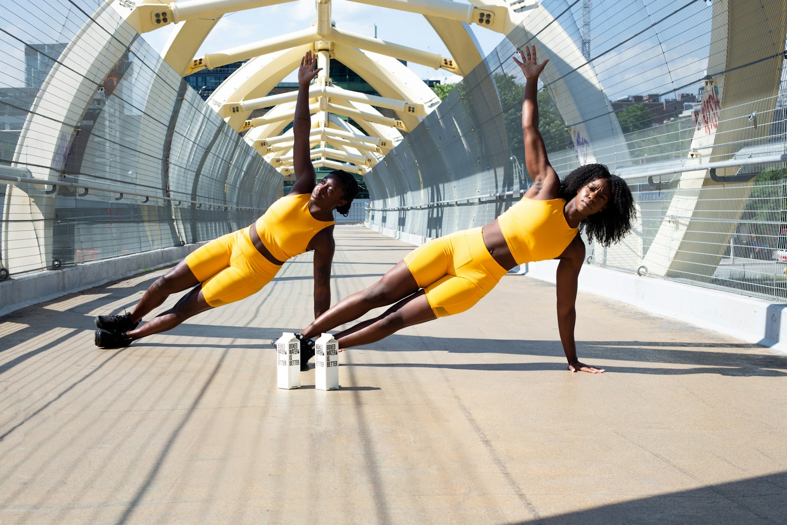 woman in yellow sports bra and yellow shorts jumping on white metal frame